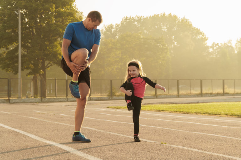 A Father and his daughter stretching before a workout