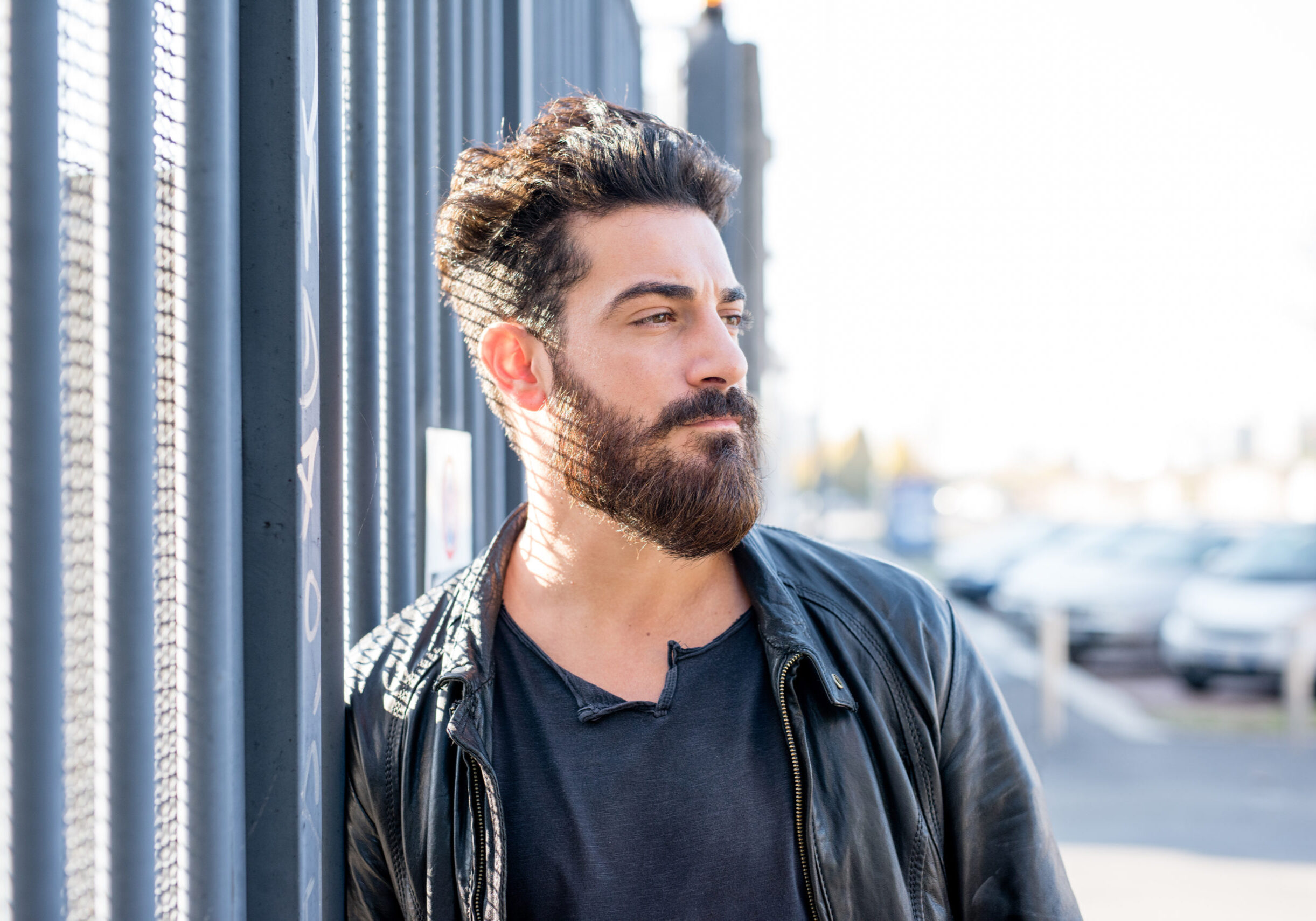 Portrait young man bearded posing outdoor with a pensive smile